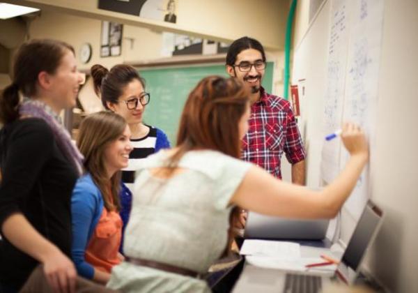 Group of students writing on a whiteboard