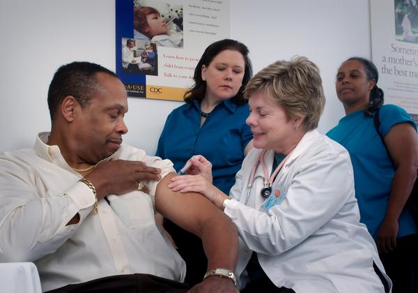 A nurse giving a man a shot