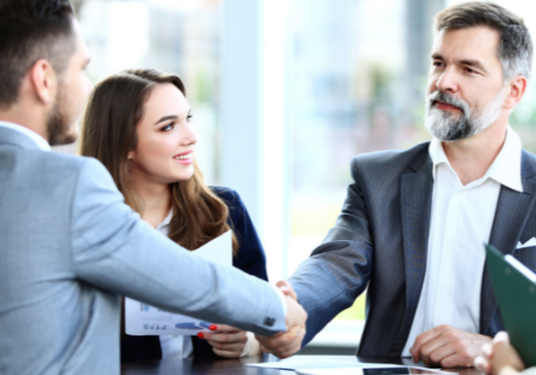 two people shaking hands over business