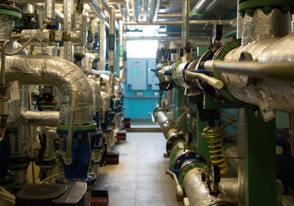 A hallway with pipes on either side in a utility plant