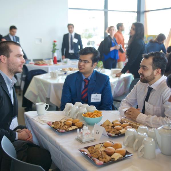 MBA internship students sitting at their table with an employer at the 2019 Multicultural Tea