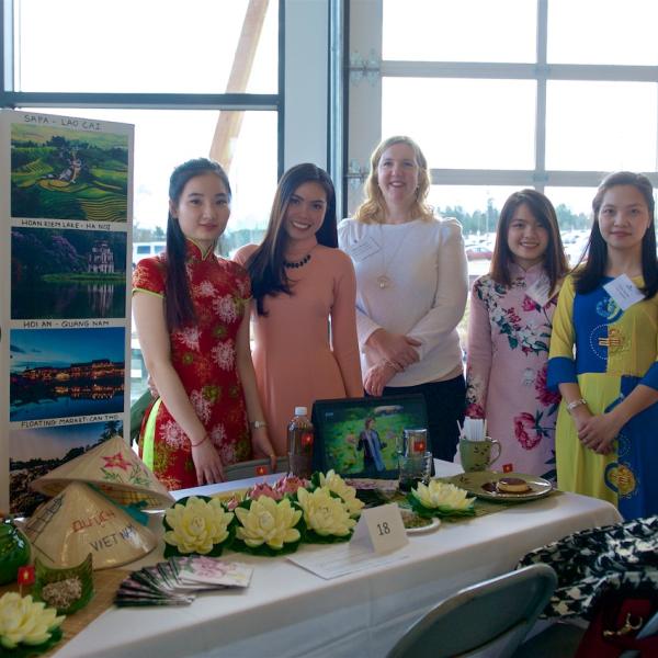 MBA internship students posing in front of their table at the 2019 Multicultural Tea