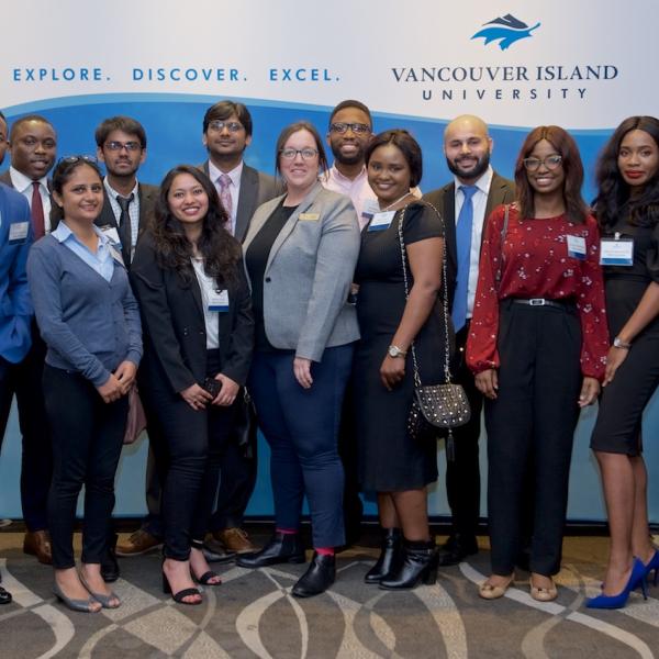 A group of MBA internship students posing for a photo at the 2019 Business Mixer at the Coast Bastion Hotel