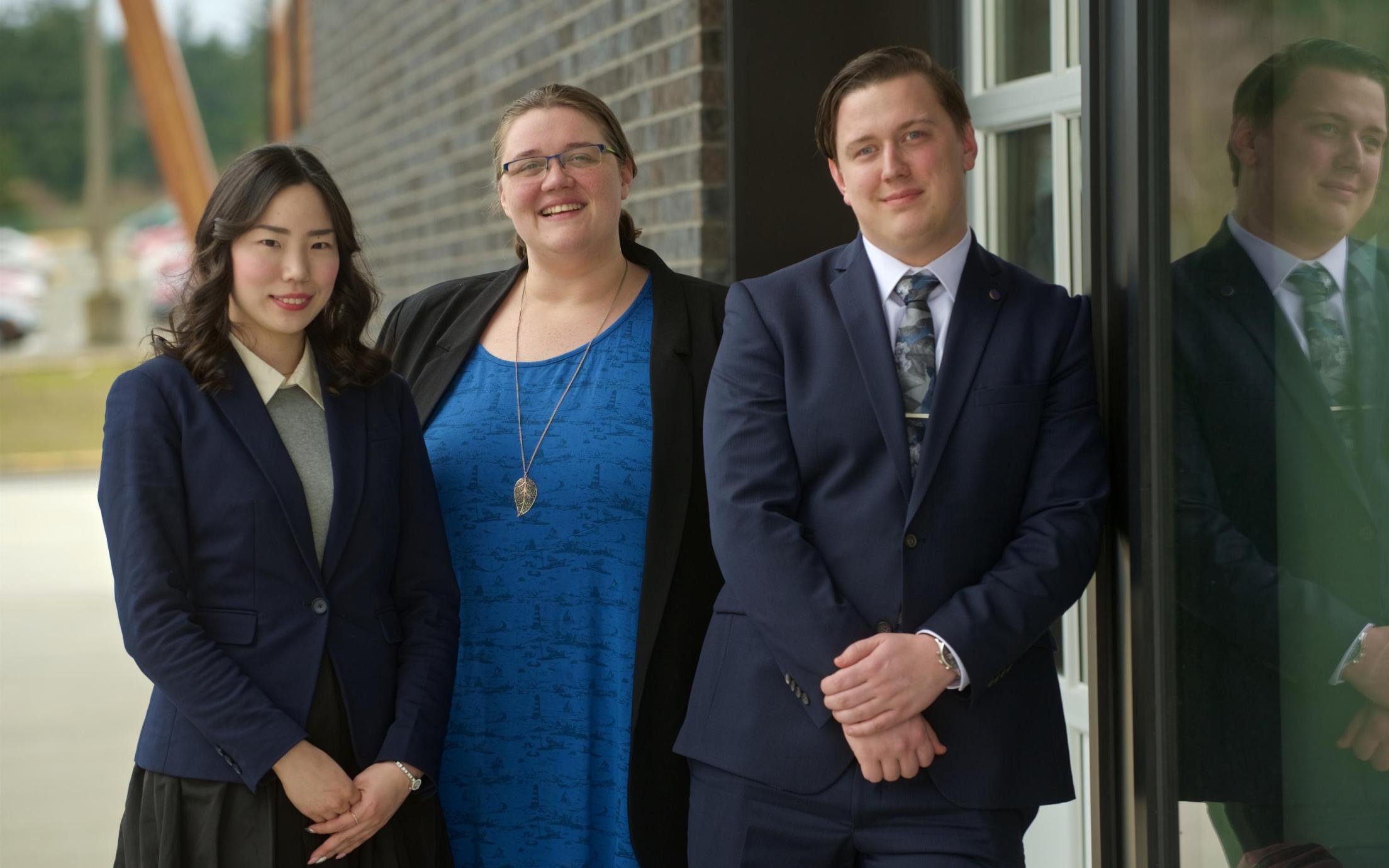 Three MBA internship students posing outside the 2019 Multicultural Tea