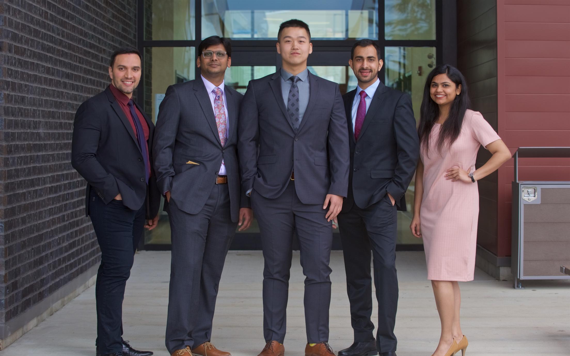A group of MBA students in business attire poseing for a picture