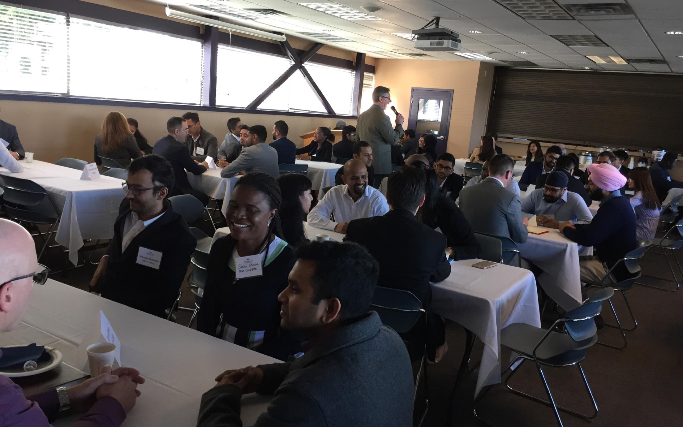 Employers and students sitting at tables during the Labour Market Round Table Event