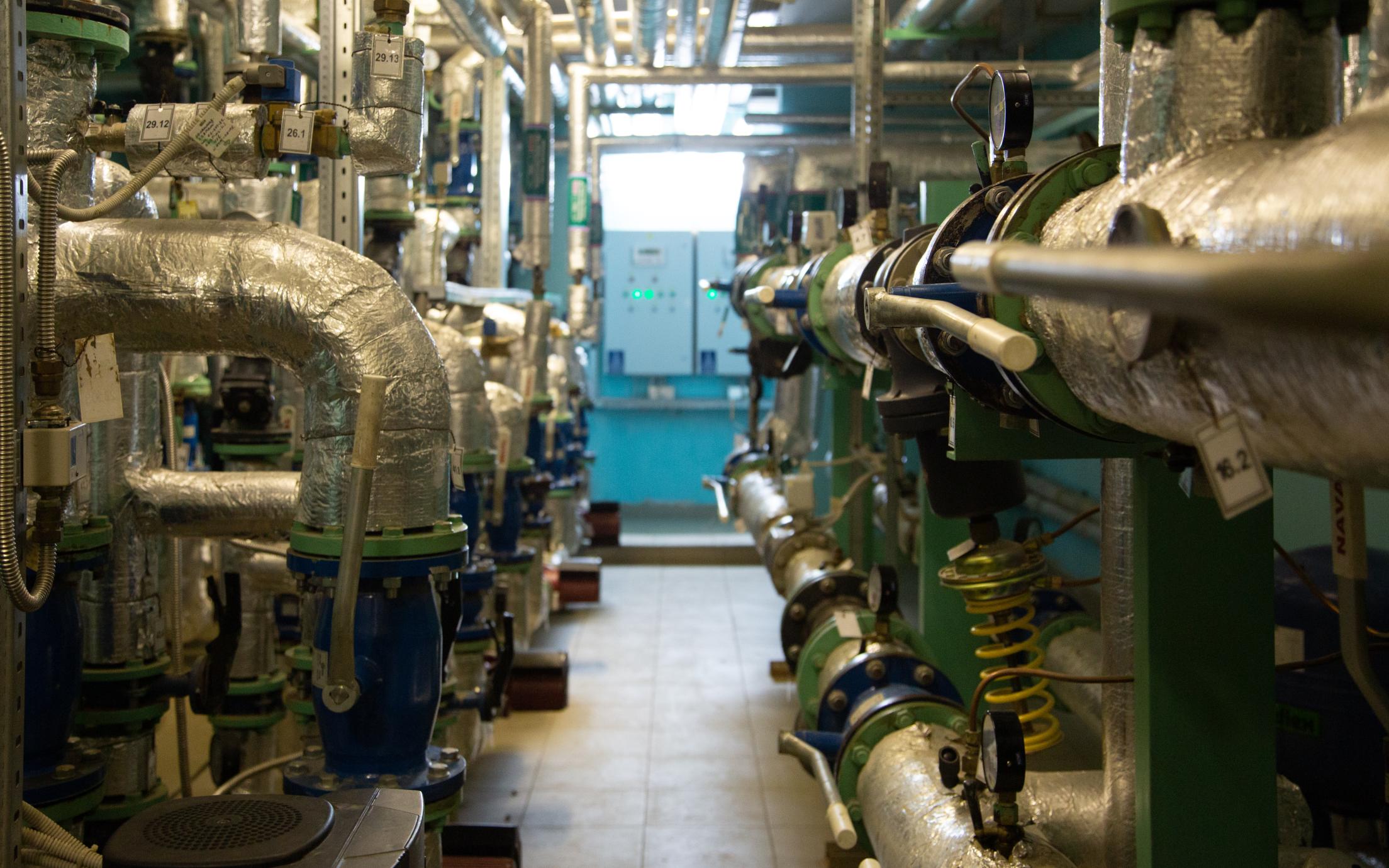 A hallway with pipes on either side in a utility plant