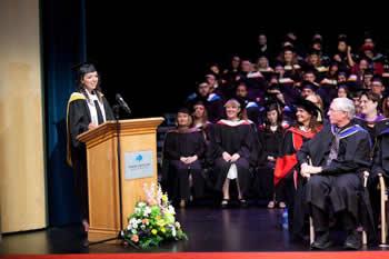 Image of valedictorian giving address at convocation ceremony
