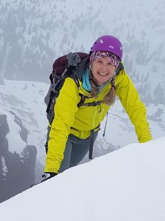 photo of Denise with helmet on, mountaineering in snow on Mt. Arrowsmith