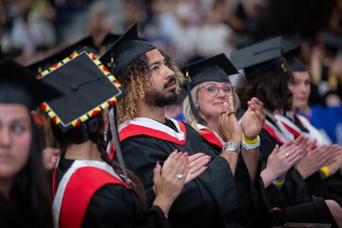 graduates in their reglia clap
