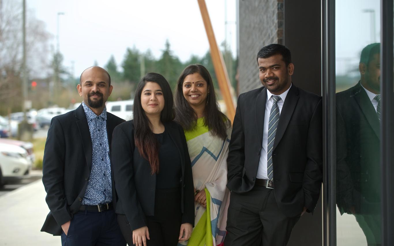 A group of four students posting for a photo
