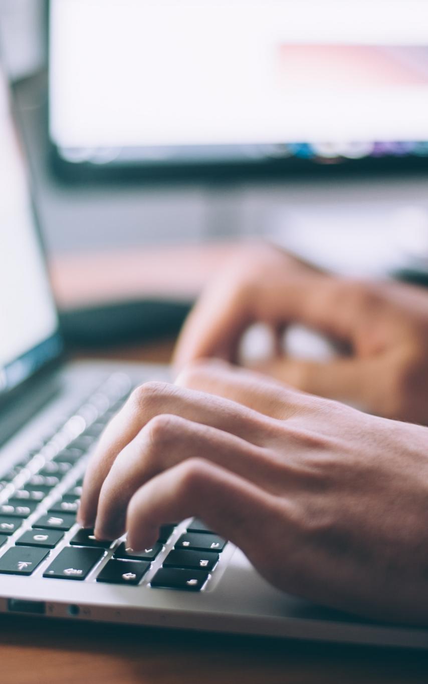 Hands on a laptop keyboard