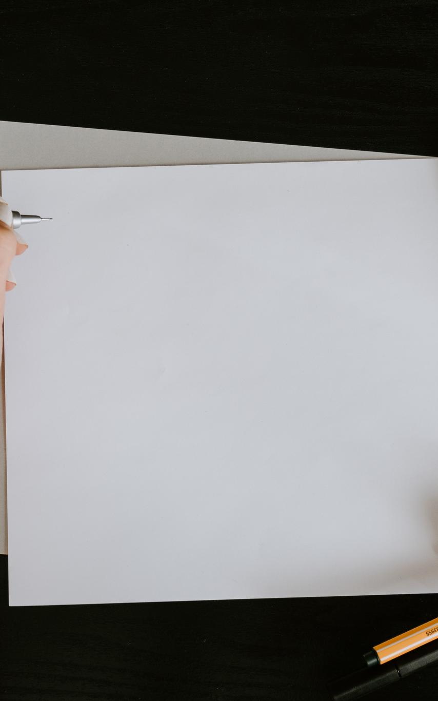 A hand with a pen over a blank piece of paper