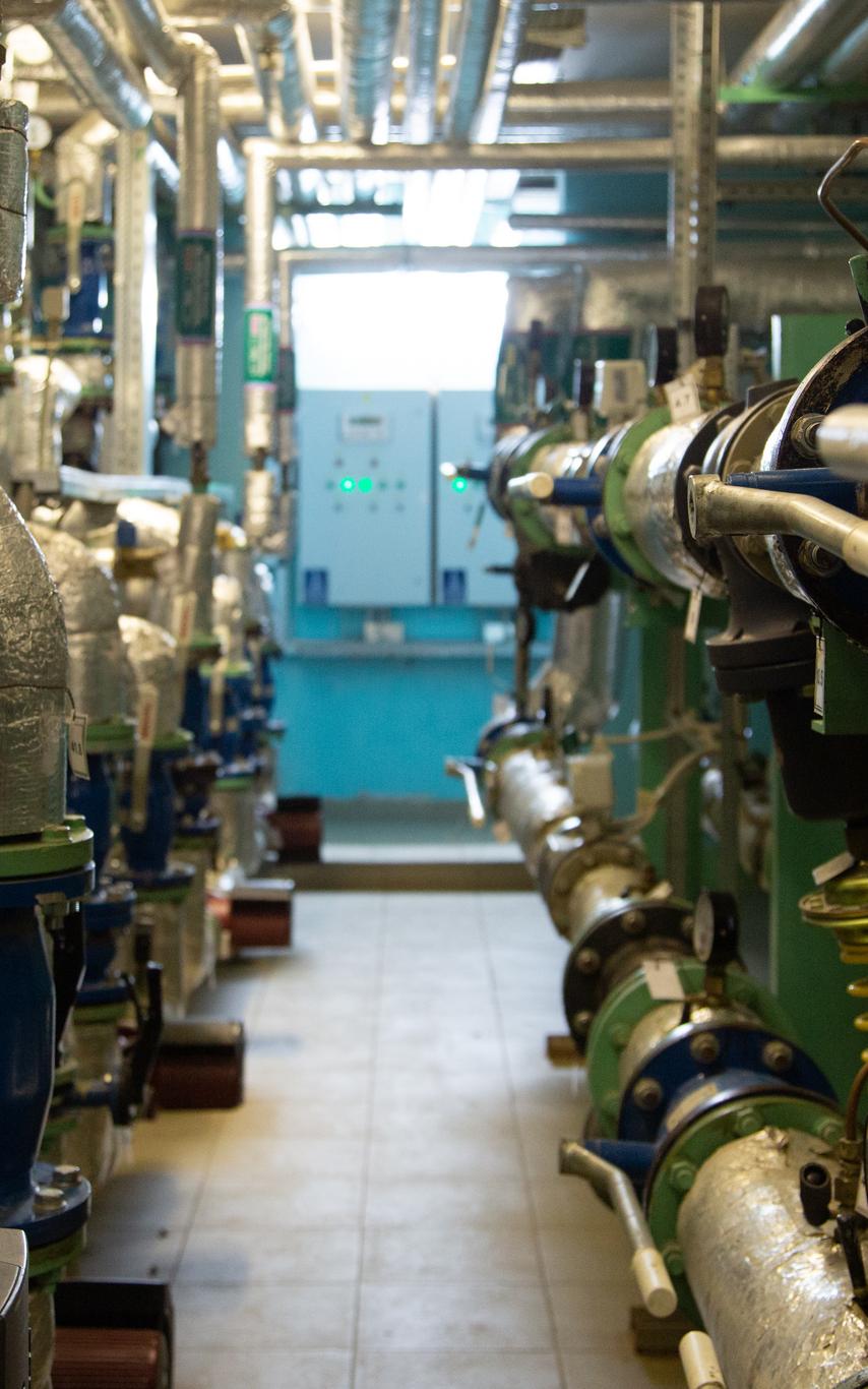 A hallway with pipes on either side in a utility plant